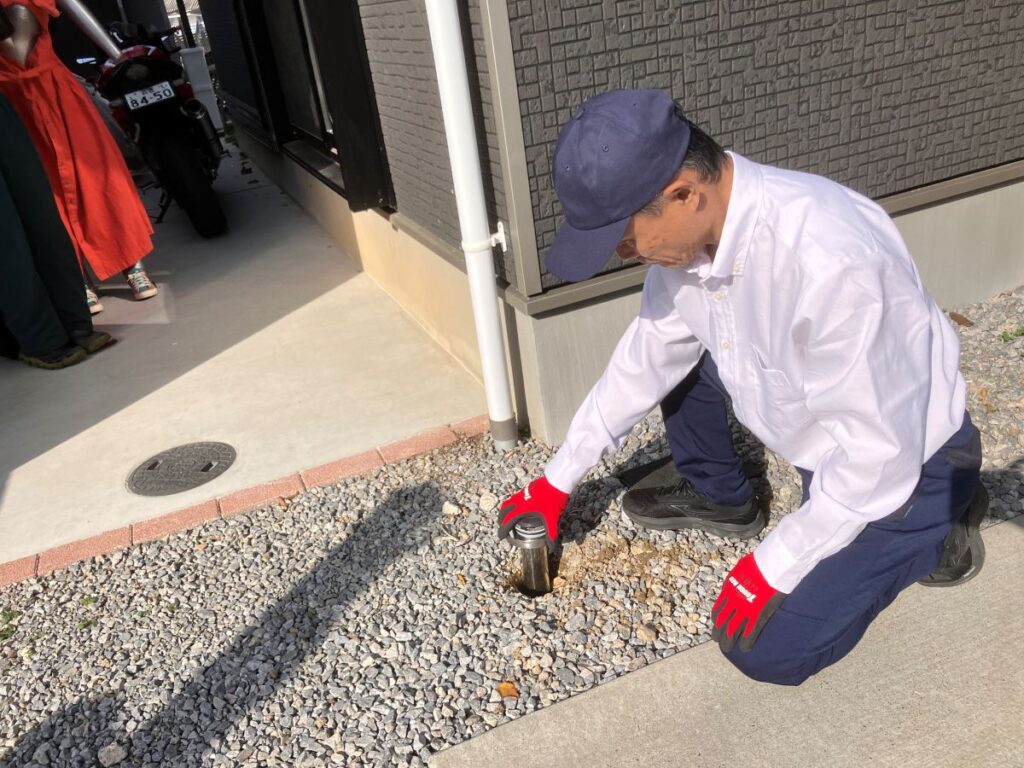 住宅外周でシロアリ点検を行う作業員