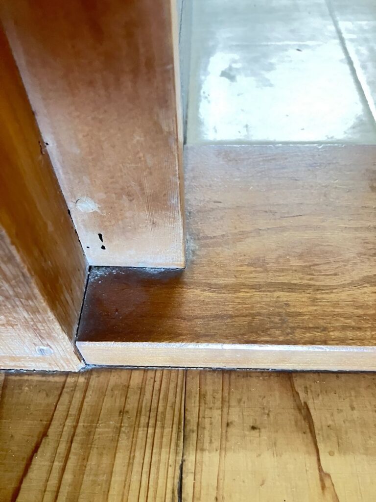 桑名市藤が丘の木造住宅で、トイレ入口の敷居の上に立つ柱の添え木に見つかった黒い虫孔